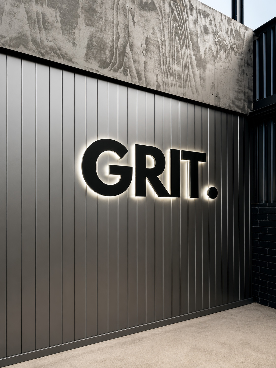 Halo-lit GRIT. fabricated lettering on dark cladding